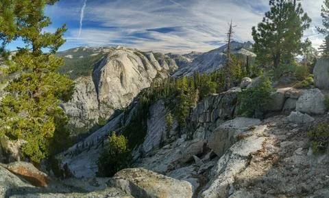 A mountain range with a clear blue sky and a few trees Stock Photos