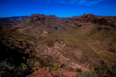 A mountain range with a clear blue sky in the background Stock Photos