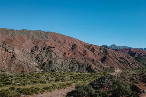 A mountain range with a clear blue sky in the background Stock Photos