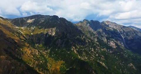 Mountain Range Cliffs Rocky Ridges Evergreen Trees Hot Summer Day Aerial Stock-Footage 300446476