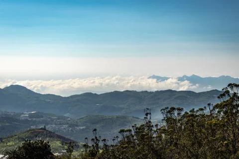 Mountain range with cloud layers and green forest Stock Photos