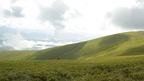 A Mountain Range, the Clouds Move Quickly. A man goes to the distance Stock Footage 74932210