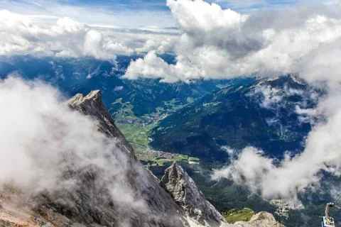 A mountain range with clouds in the sky view of the alps from zugspitze mountain Stock Photos