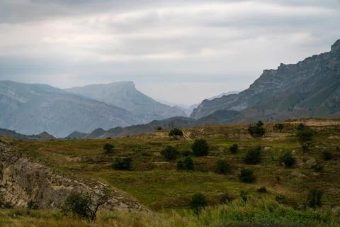 A mountain range with a cloudy sky in the background. The sky is overcast and Stock Photos