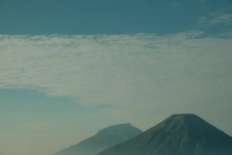 A mountain range with a cloudy sky in the background Stock Photos