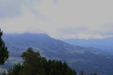 A mountain range with a cloudy sky in the background Stock Photos
