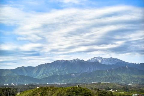 A mountain range with a cloudy sky in the background Stock Photos