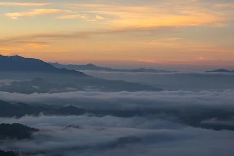 Mountain Range Covered in Clouds at Sunrise 스톡 사진