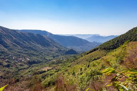 Mountain range covered with dense green forests and bright blue sky at mornin Stock-Fotos