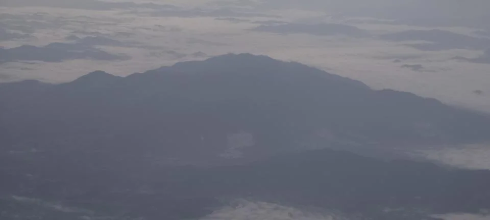A mountain range covered in mist and low‑lying clouds Photos