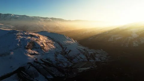 A mountain range covered in snow and a rocky desert Stock Footage 328246816