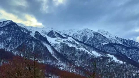 A mountain range covered in snow with a cloudy sky in the background Vidéo 273445327