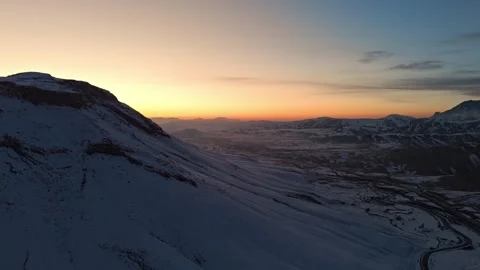 A mountain range covered in snow at sunset time Видео 328249090