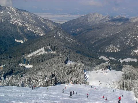 Mountain range covered with winter forest. Low Tatras. Skiers downstairs. Low Ta Stock Photos