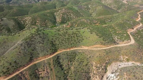 A mountain range with a dirt road in the middle Stock Footage 306417026