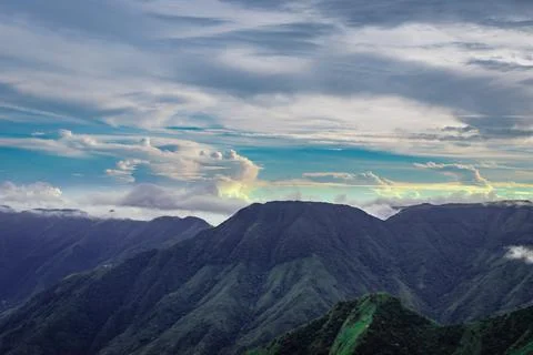 Mountain range with dramatic sunset sky and low clouds at evening 스톡 사진