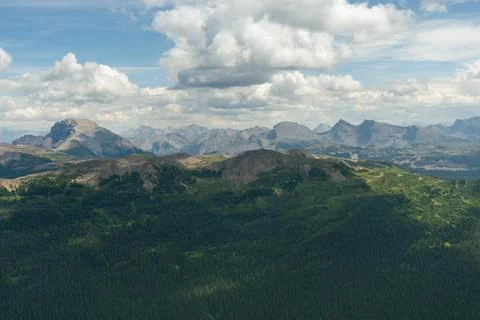 Mountain range with green forest and dramatic clouds Stock Photos