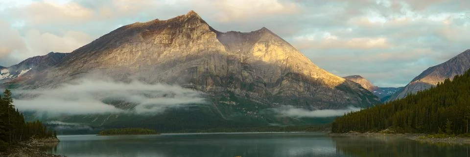 A mountain range with a lake in the foreground Stock Photos