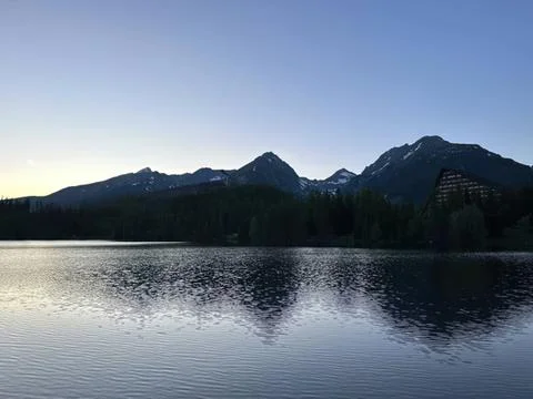 Mountain range with lake under clear blue sky Stock Photos
