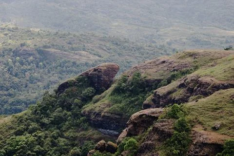 A mountain range with a large rock formation in the middle Stock Photos
