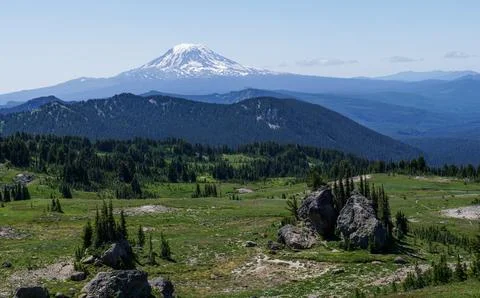 A mountain range with a large snow covered peak in the distance Stock Photos