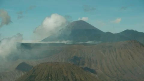A mountain range with a large volcano in the background Stock Photos
