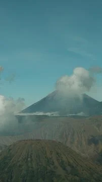 A mountain range with a large volcano in the background Stock Photos