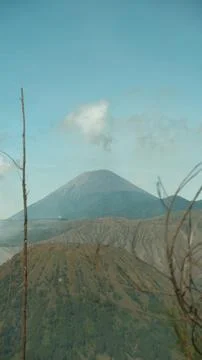 A mountain range with a large volcano in the middle Stock Photos