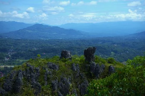 A mountain range with a lush green hillside and a rocky peak Stock Photos