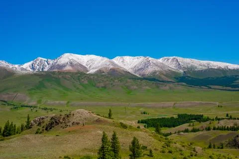 Mountain range with melting snow. View from the valley Stock Photos