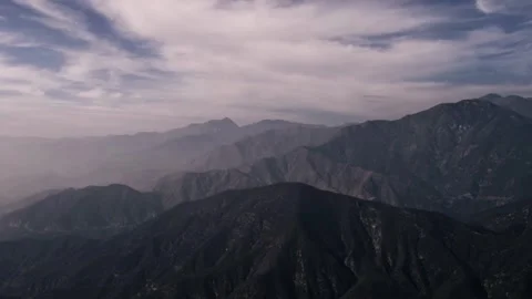 Mountain range multiple layers atmospheric cloudy serene vista Stock Footage 329543479