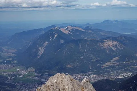 Mountain Range Overlooking Town with Rock Peak Foreground Stock Photos