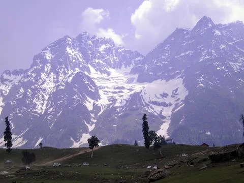 Mountain range with partial snow coverage against a clear blue sky Stock Photos
