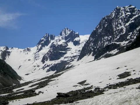 Mountain range with partial snow coverage against a clear blue sky Stock-Fotos