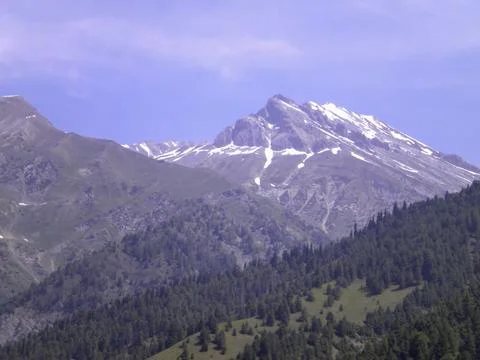 Mountain range with partial snow coverage against a clear blue sky Фото