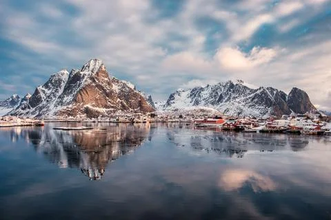 Mountain range reflection on arctic ocean with scandinavian village on winter Stock Photos