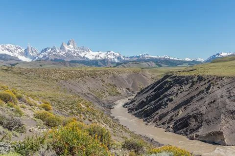 A mountain range with a river running through it and Mount Fitz Roy at the Stock Photos