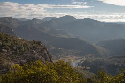 Mountain range, river winding through valley landscape Stock Photos