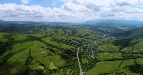 Mountain range, road, green fields, moving clouds, forest, village Stock Footage 139262787