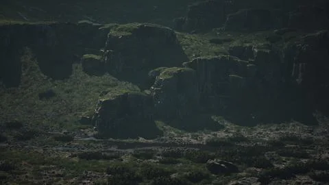 A mountain range with rocks and grass in the foreground Stock Illustration
