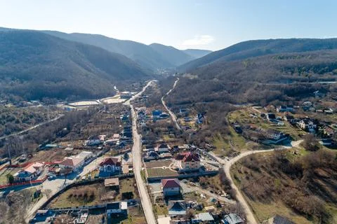 A mountain range with a small town in the valley Stock Photos