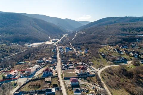 A mountain range with a small town in the valley Stock Photos