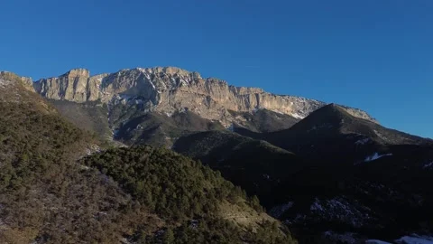 A mountain range with snow and trees in the background Видео 328615428