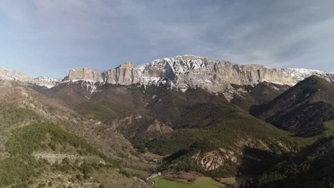A mountain range with snow capped mountains and a valley Stock Footage 329627933