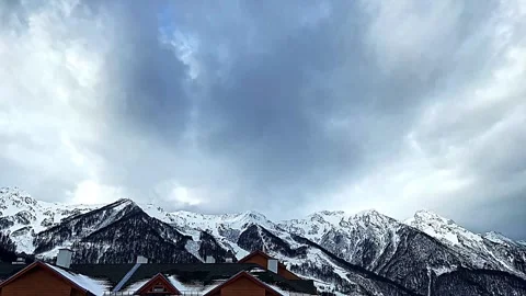 A mountain range with snow on it and a cloudy sky Vidéo 269868975