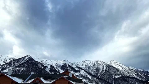 A mountain range with snow on it and a cloudy sky Stock-Footage 270742600