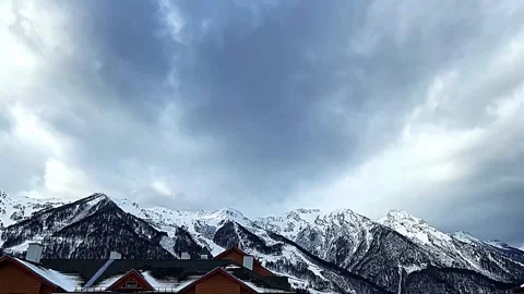 A mountain range with snow on the peaks and a cloudy sky 스톡 동영상 270742086