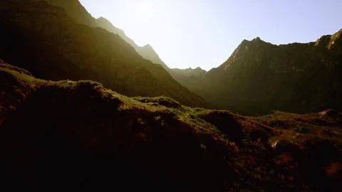 A mountain range with sun shining through. mountain sunset イラスト素材