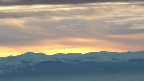 Mountain range at sunset with colorful sky and scenic winter views Video stock 304667329