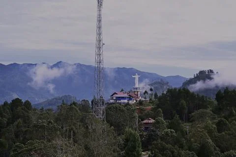 A mountain range with a tall tower in the middle Stock Photos